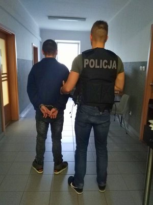 policjant prowadzi zatrzymanego