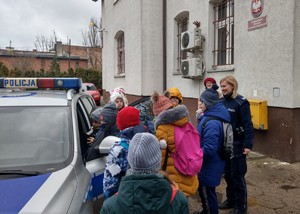 Dzieci oglądają policyjny radiowóz.