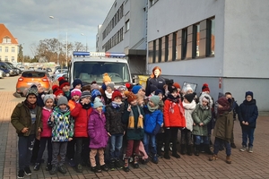 wspólne zdjęcie dzieci z policjantką na tle radiowozu