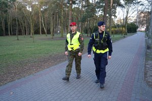 policjant z żandarmem idą chodnikiem i patrolują ulice