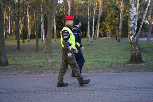 policjant z żandarmem idą chodnikiem i patrolują ulice