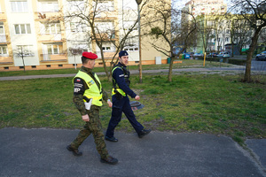 policjant z żandarmem idą chodnikiem i patrolują ulice