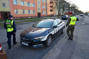 policjant z żandarmem wsiadają do radiowozu żandarmerii wojskowej