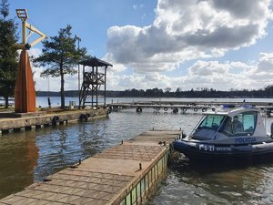 Policyjna łódź motorowa zacumowana przy pomoście.