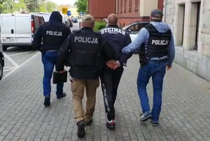 policjanci prowadza zatrzymanego do sądu