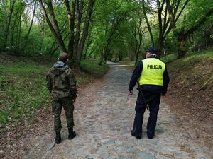 Policjant i żołnierz Wojsk Obrony Terytorialnej podczas patrolu terenów leśnych.