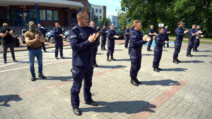 policjanci stoją i klaszczą