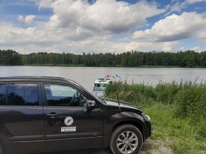 Pojazd Leśników na akwenem. W tle pływająca łódź policyjna.