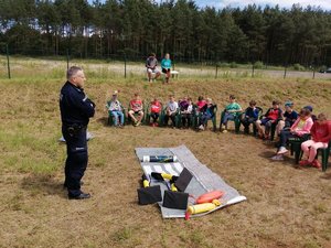 Policjant podczas spotkania z uczestnikami półkolonii w terenie zielonym (1)