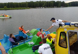 Policjant podczas interwencji wobec pływających na jeziorze.