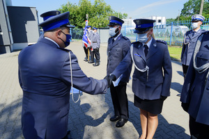 Komendant wręcza policjantowi rozkaz