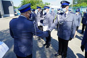 Komendant wręcza policjantowi rozkaz