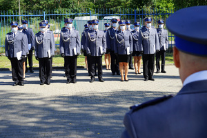 Komendant przemawia do policjantów. W tle stoją policjanci w szeregu