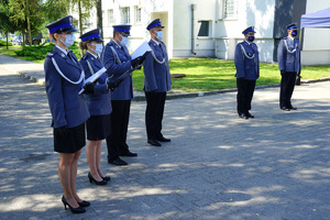 rozpoczęcie uroczystości. Policjant odczytuje rozkaz. Obok stoją policjanci oraz dwóch komendantów