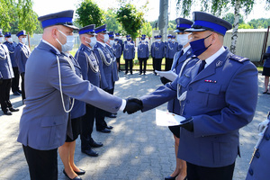 Komendant wręcza policjantowi rozkaz