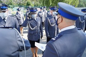 Komendant wręcza policjantowi rozkaz