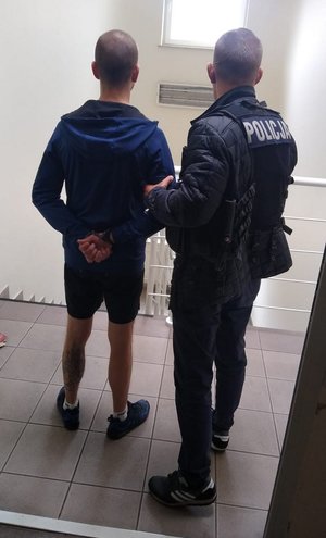 Policjant prowadzi zatrzymanego (2).