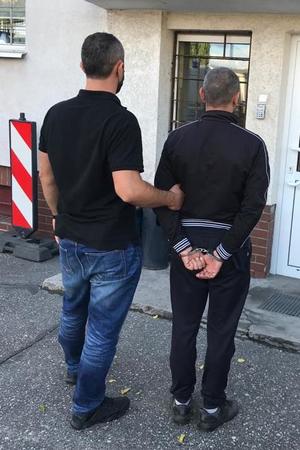 Policjant prowadzi zatrzymanego.(2)