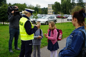 Policjantka wręcza dzieciom odblaski.