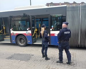 Policjanci stoją przy autobusie mzk.