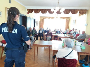 Policjantka rozmawia z seniorami.