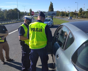 Policjanci podczas kontroli drogowej pojazdu.