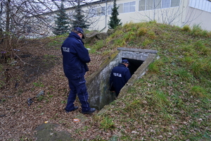 Policjanci wchodzą go schronu w ziemi zajmowanego przez bezdomnego.