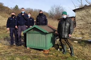 policjanci, pracownik OTOZ i pies stoją koło budy