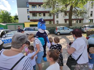 Osoba przebrana za policyjną maskotkę Polfinka bawi się z dziećmi