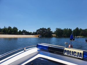 Widok na jezioro z policyjnej łodzi motorowej.