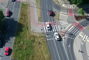 Pojazd jadący lewym pasem wyprzedza na przejściu dla pieszych pojazd jadący prawym pasem.