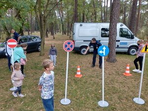 Policjant instruuje chłopca, który pokonuje tor w alkogoglach.