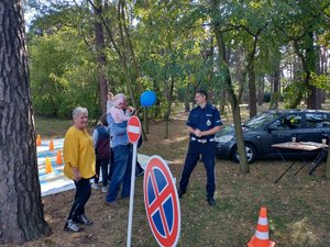 Policjant rozmawia z uczestnikami festynu.