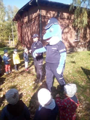 Polfinek i policjantka w grupie dzieci stojących dookoła nich.