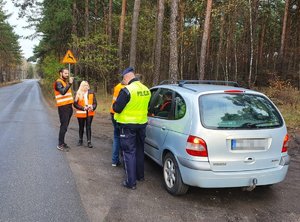 Służby podczas kontroli drogowej pojazdu renault.