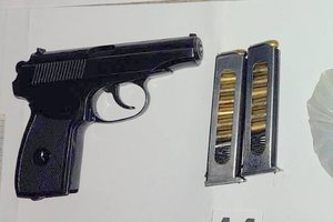 czarny pistolet z dwoma magazynkami z nabojami leżą na białej kartce