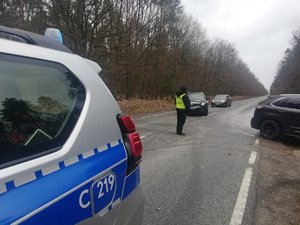 Policjant kieruje ruch pojazdów na objazd.