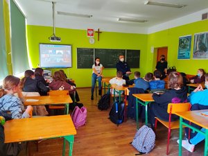 Uczniowie i policjanci podczas zajęć w klasie szkolnej.