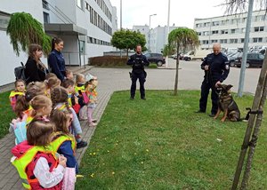 policjanci z psami służbowymi rozmawiają z dziećmi