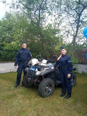 Policjanci stoją przy policyjnym quadzie.