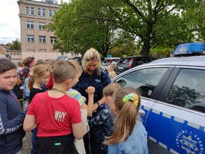 Policjantka i stojący dookoła niej uczniowie.