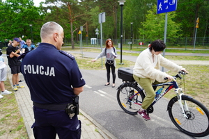 policjant przygląda się jeździe na rowerze egzaminowanej dziewczyny