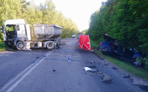 widok na dwa rozbite pojazdy. Jeden ciężarowy po lewej stronie i drugi na poboczu po prawej stronie