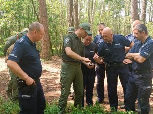 policjanci i strażnicy leśni stoją obok siebie