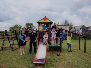 Zdjęcie grupowe uczestników spotkania w terenie zielonym.