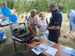 Kobieta i mężczyzna rozmawiają z technikiem kryminalistyki.