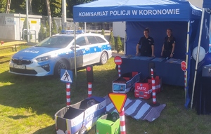 Namiot policyjny, pod którym stoją dwie policjantki.