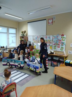 dzieci w autochodzikach ćwiczą z policjantkami