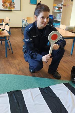 policjantka pokazuje tarcze do zatrzymywania pojazdów