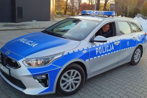 policjant post. Marcin Rychczyński siedzi w oznakowanym radiowozie